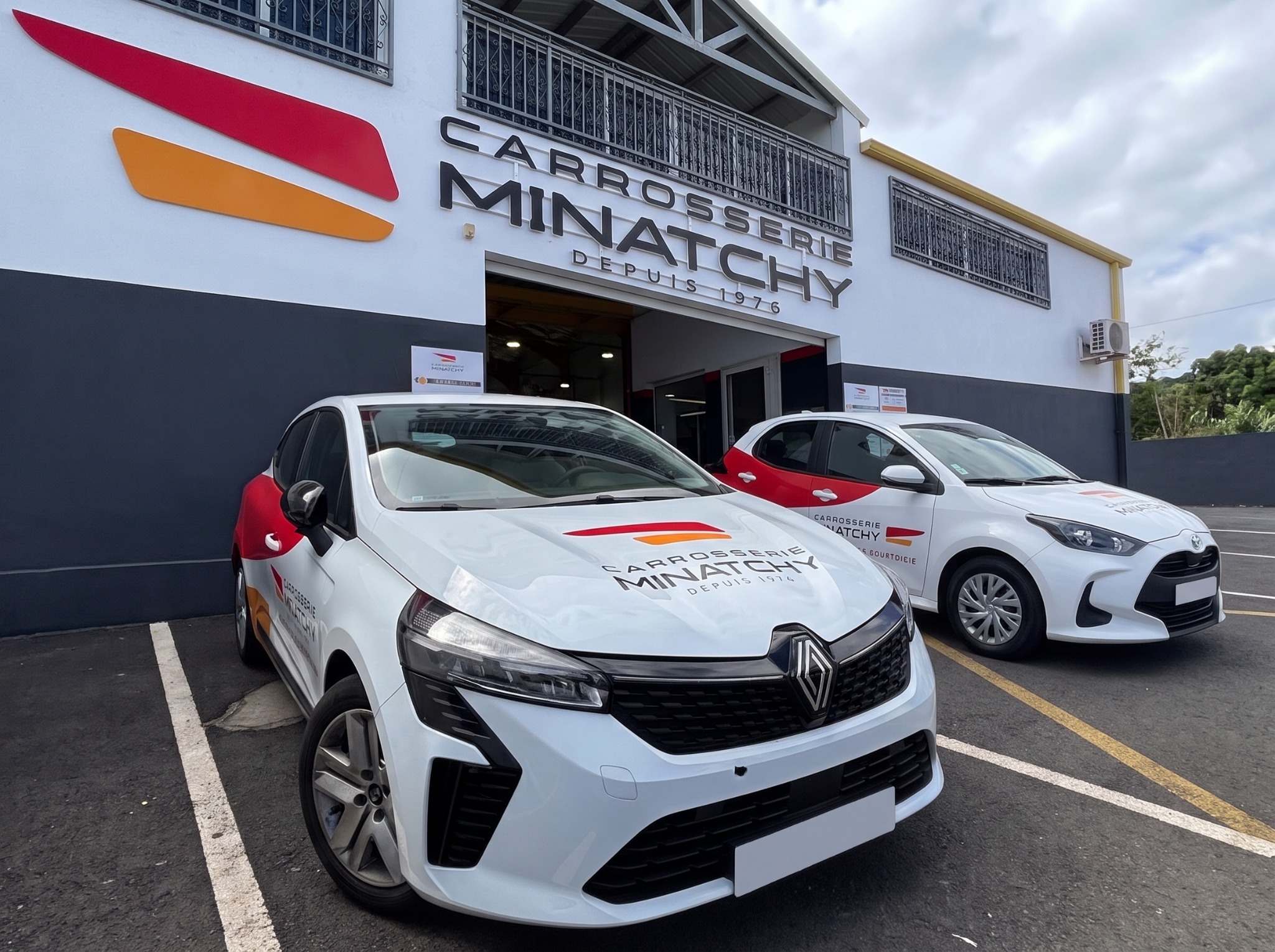 Deux véhicules Carrosserie Minatchy devant l'agence
